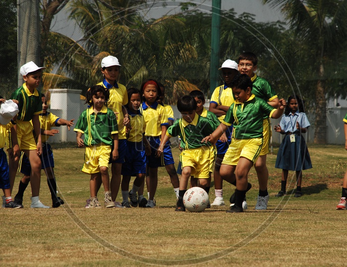 School Boys Playing Football  in Ground