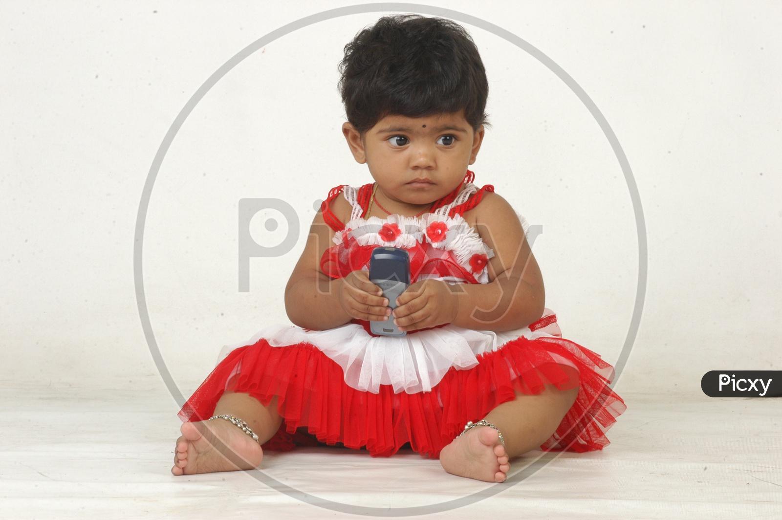 Indian Girl kid in a studio with a mobile phone