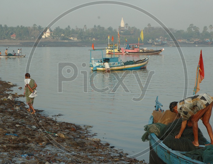 Fisher Man in Fishing Boats at the Bank of a River
