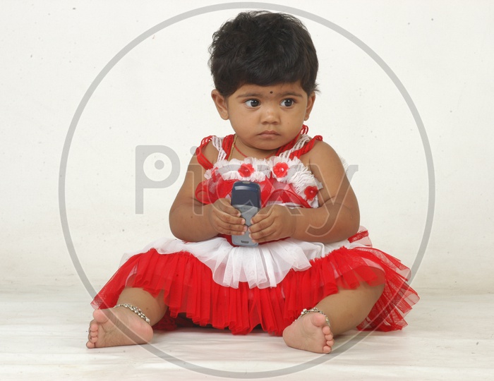 Indian Girl kid in a studio with a mobile phone