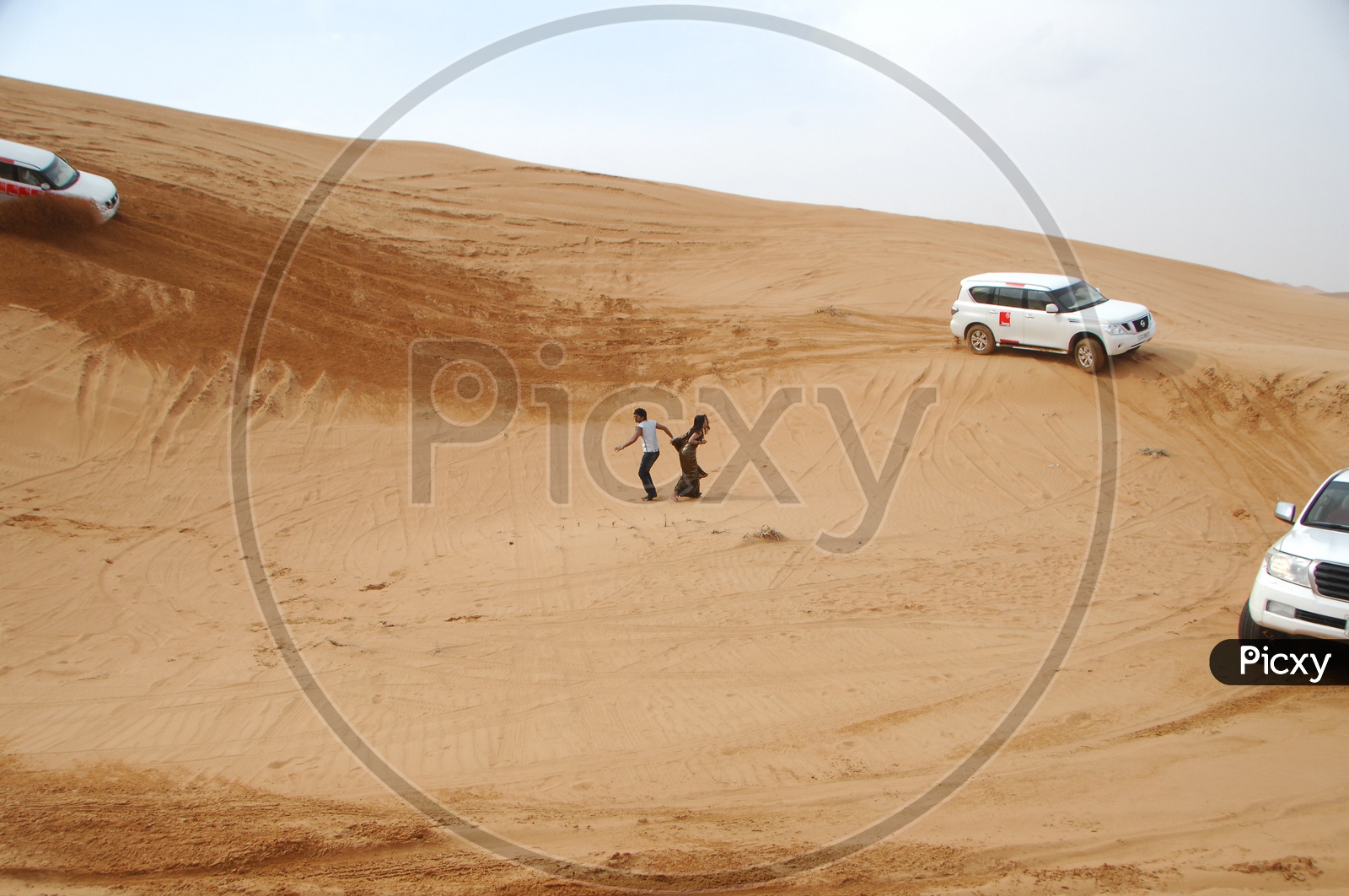 Indian Couple Surrounded By Desert Safari Vehicles in desert