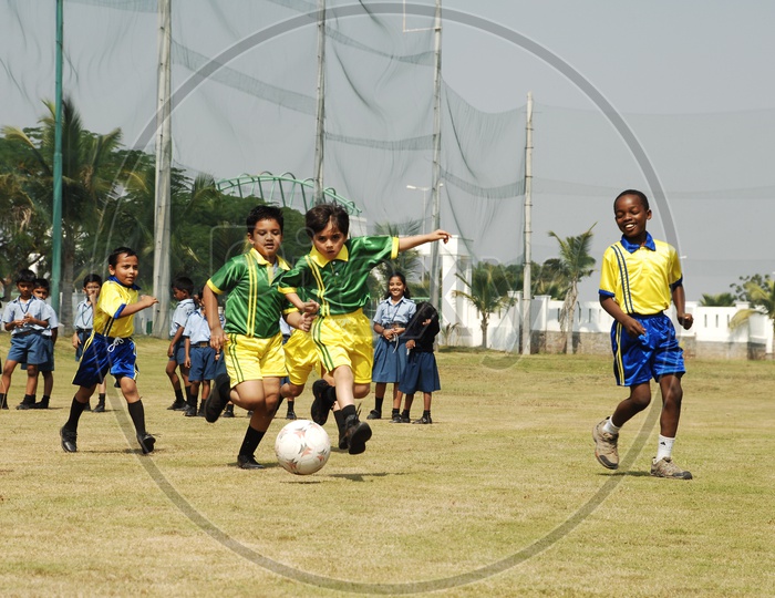 School Boys Playing Football  in Ground