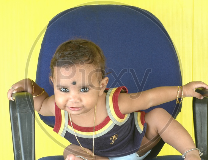 Indian Girl kid in a studio in chair