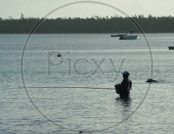A Fisherman Fishing With a Fishing Rod