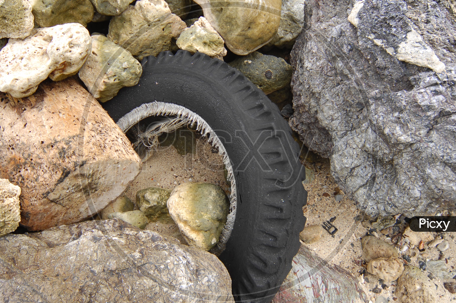 old rubber tyre in stones