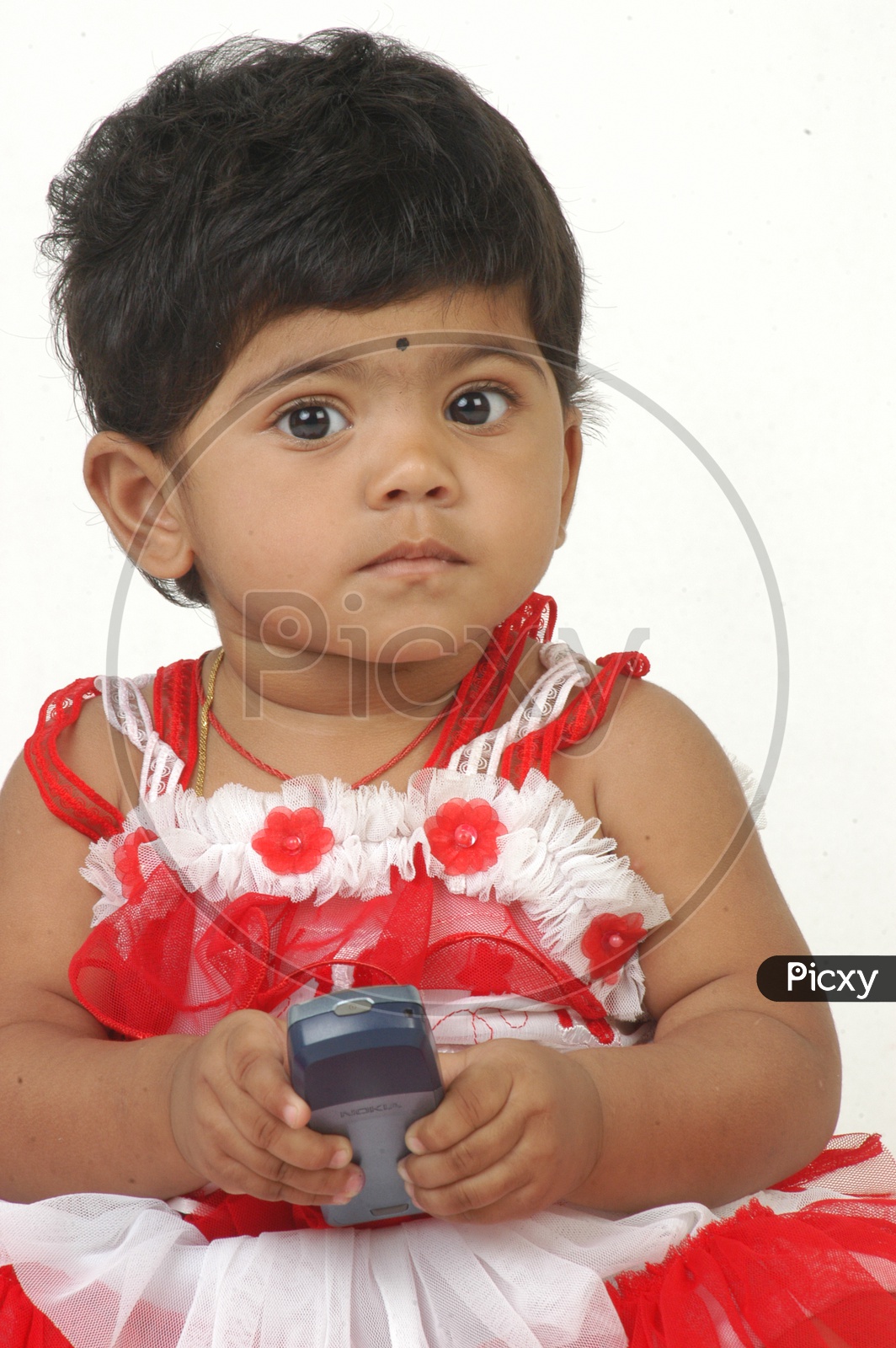 Indian Girl kid in a studio with nokia mobile in hand