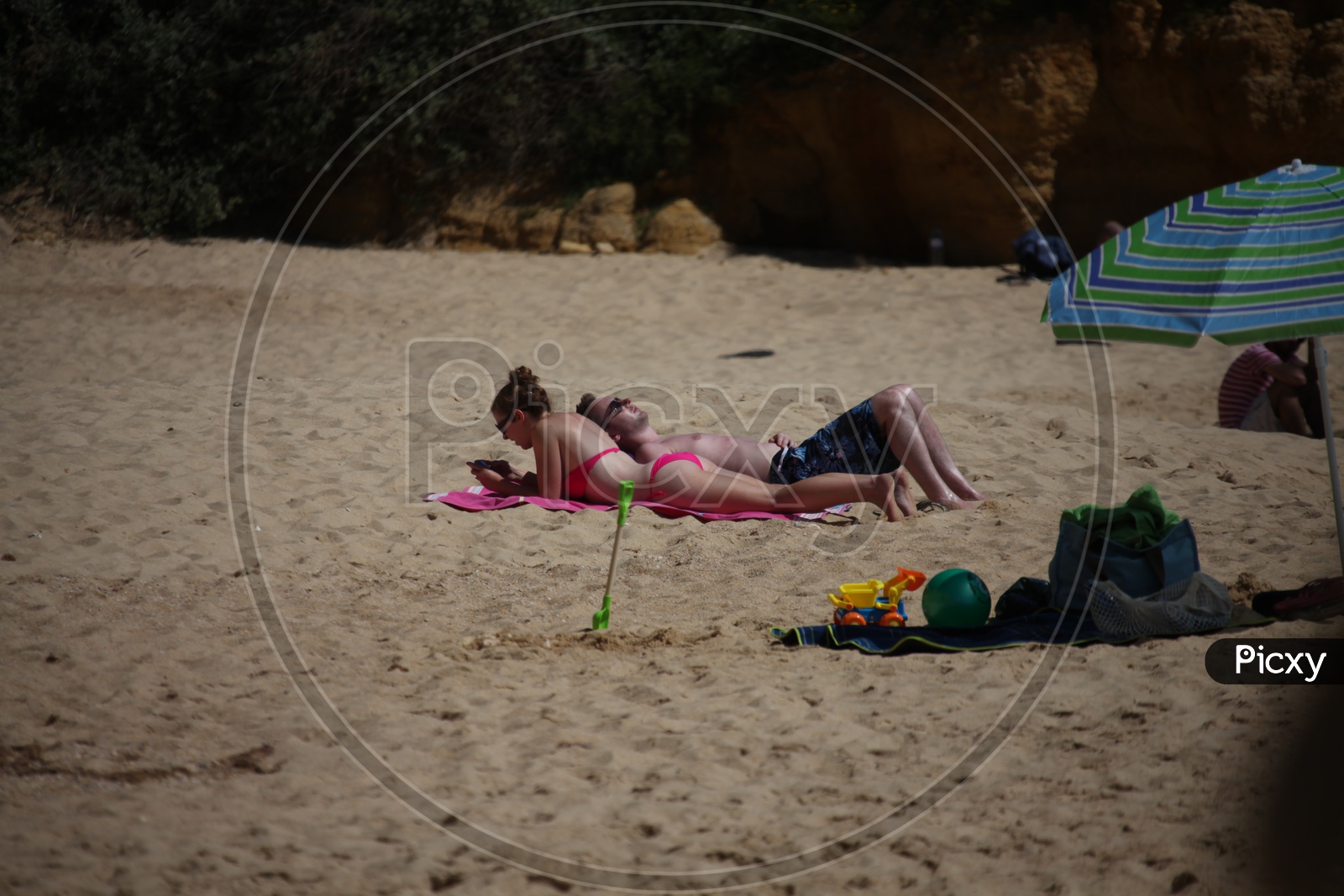 A Couple Lying in a Beach Side by side