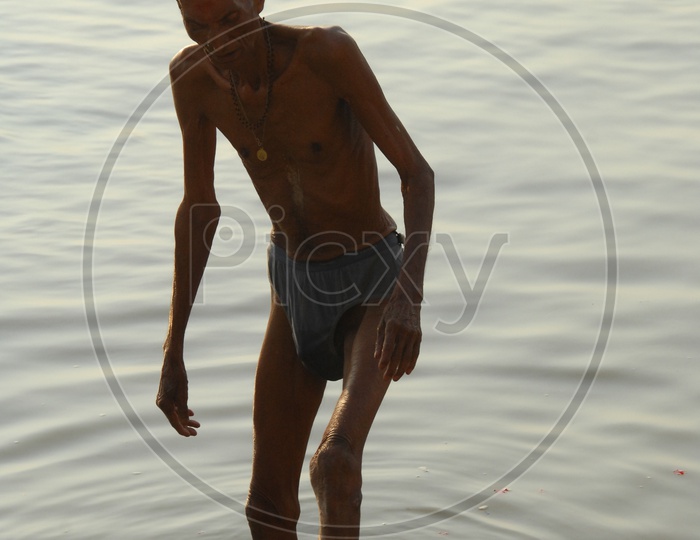 Old man bathing in River Ganga in Varanasi