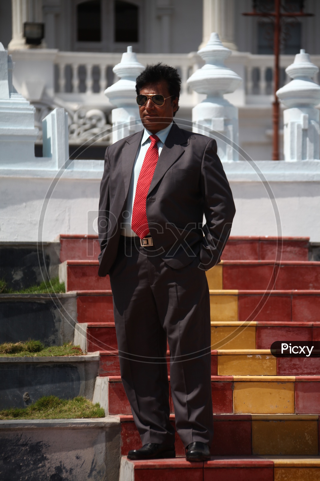 A man walking down the stairs in suit with goggles