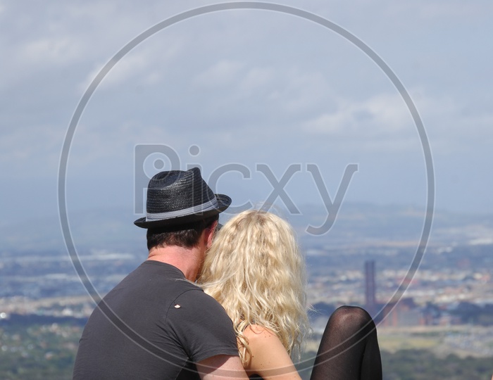 A Foreign Couple Watching a City Scape From a Hill Top