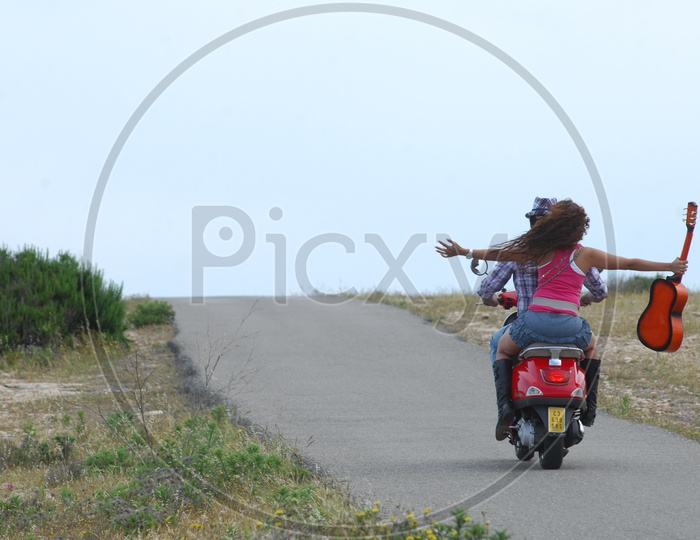 A Couple Riding on a Bike / Moped / Scooty