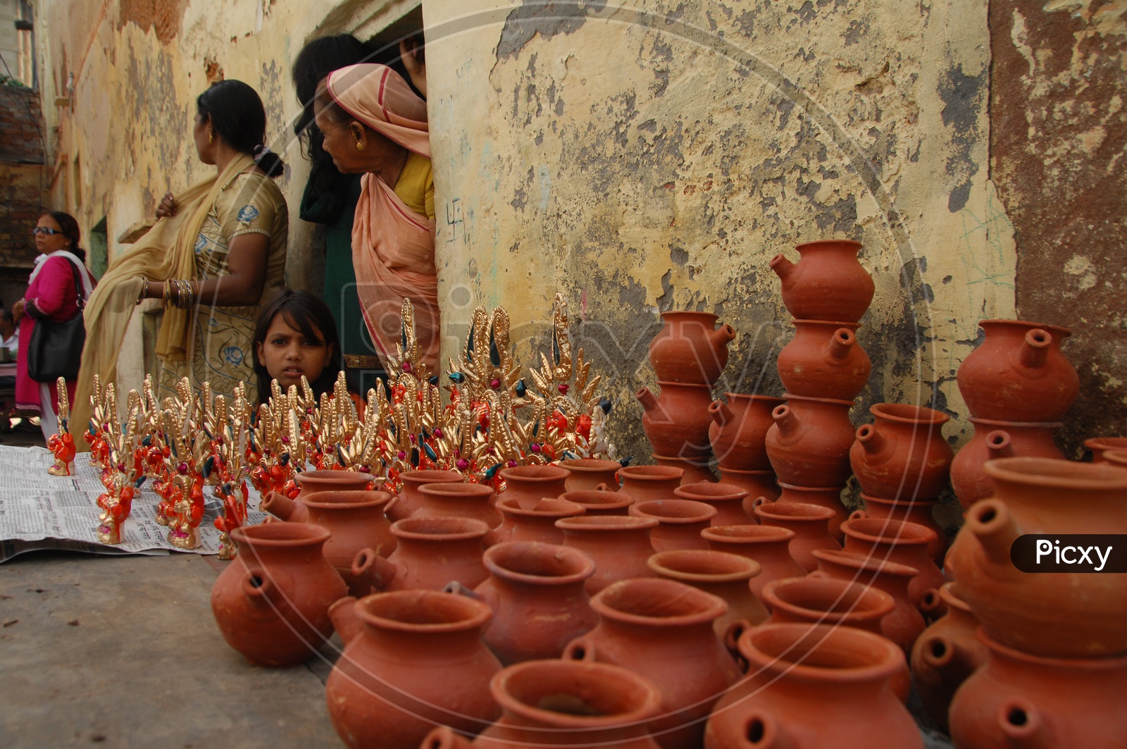Photograph of a old women with pots in the foreground / People Faces