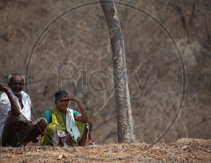Old couple sitting in a dry land