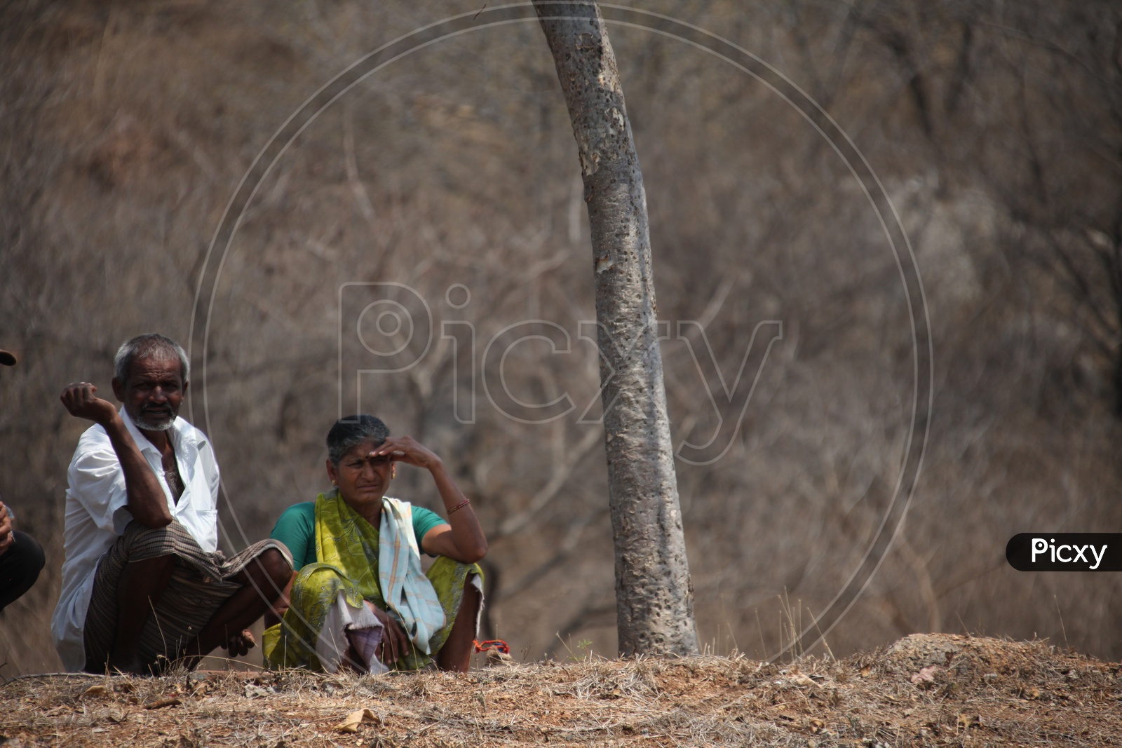 Old couple sitting in a dry land