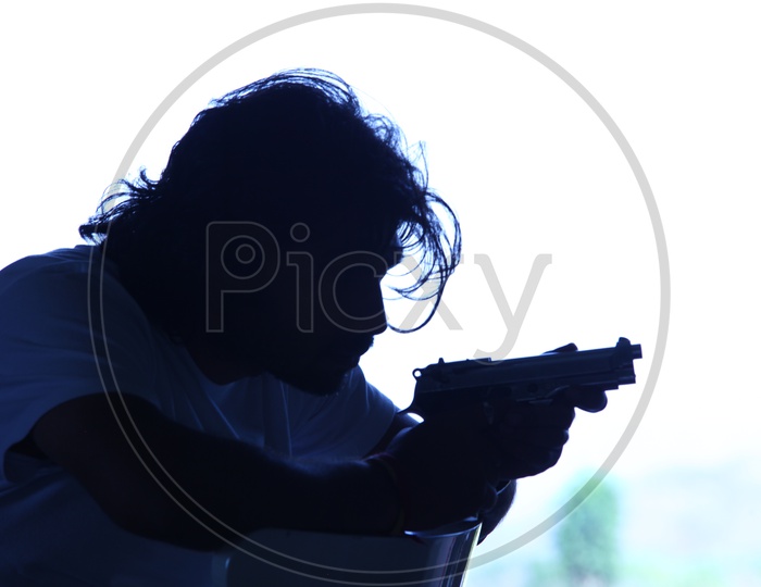 Silhouette of A Man Holding a Pistol / gun