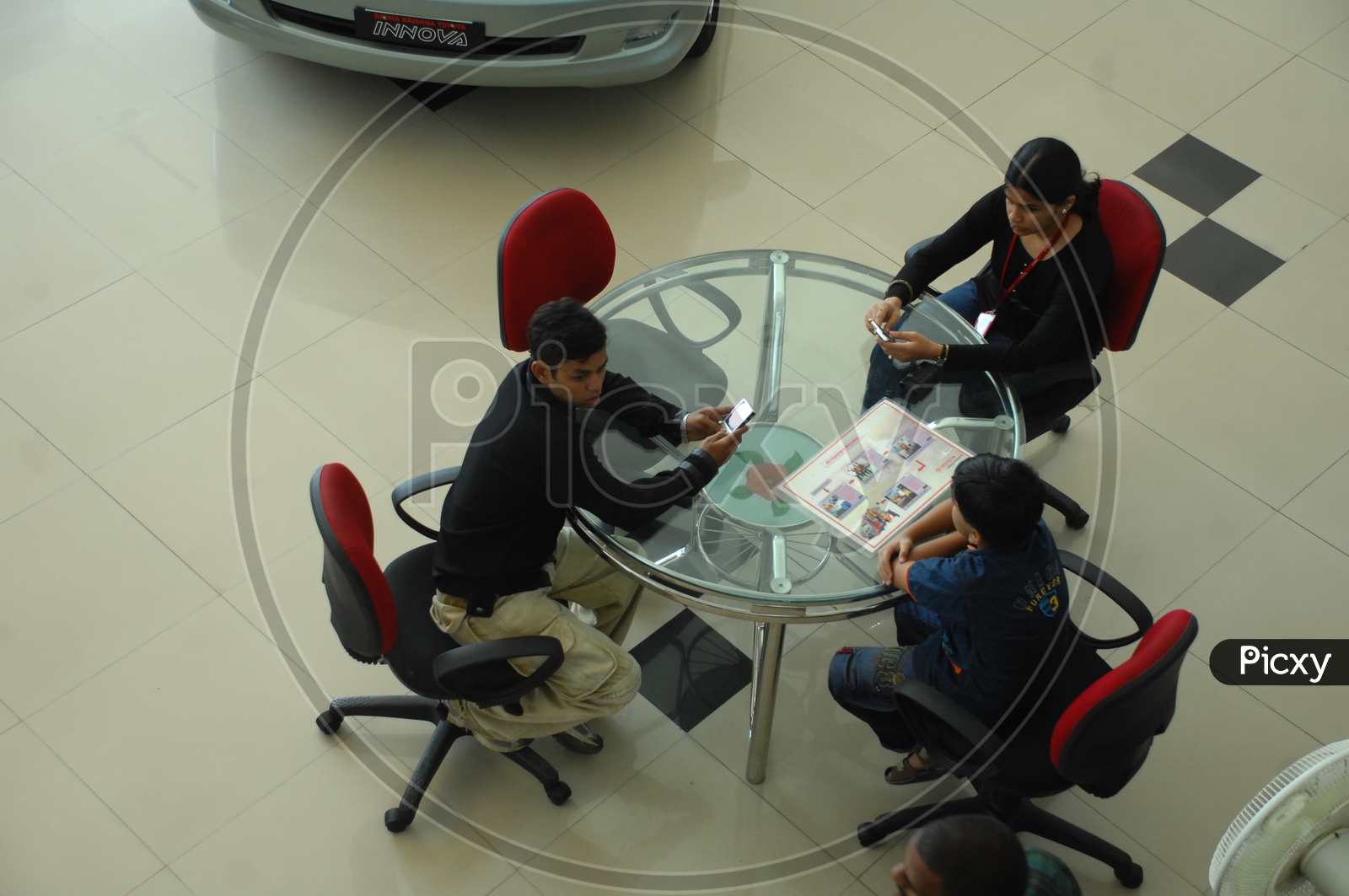 Kids sitting near a table in a car showroom