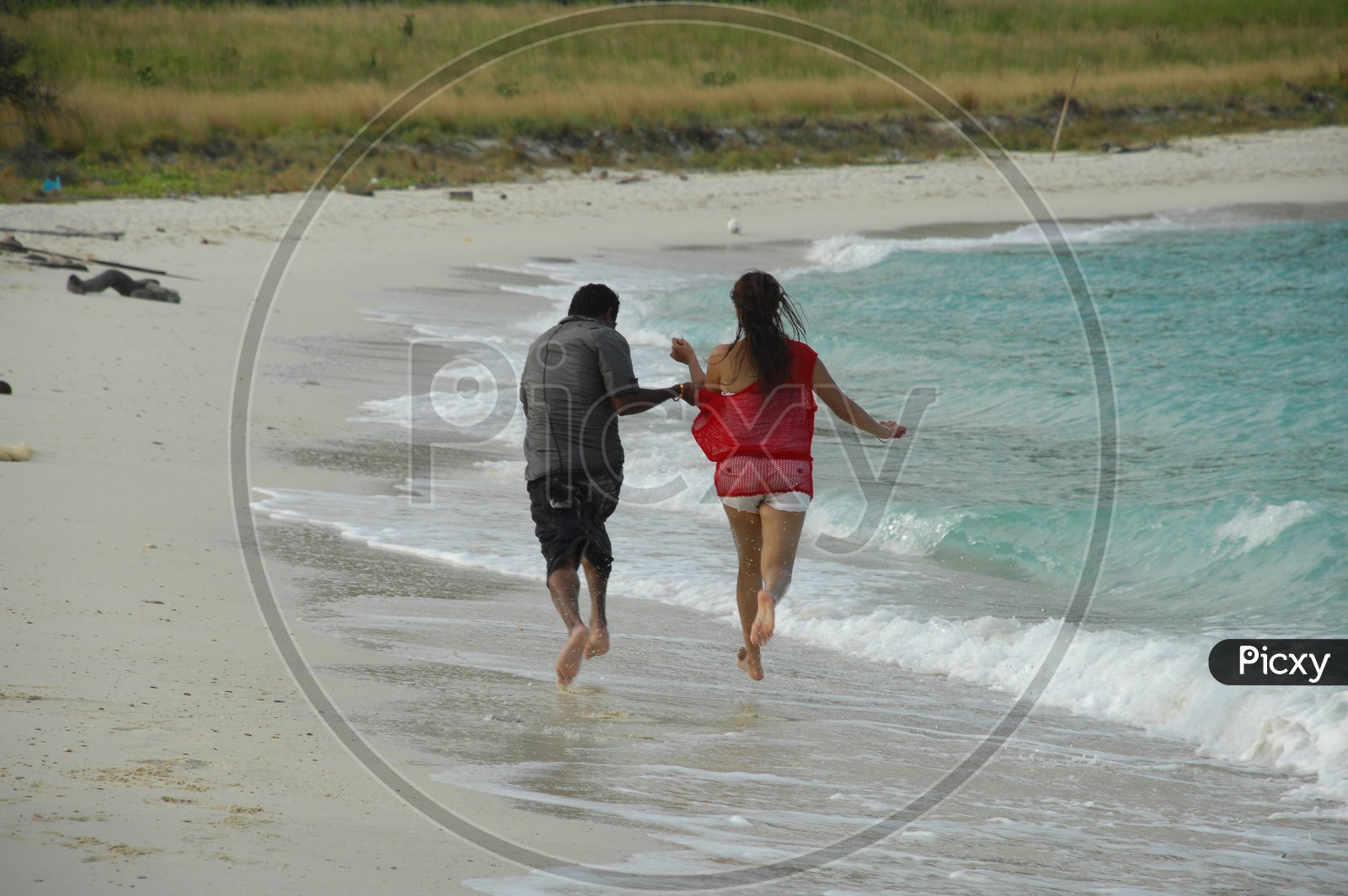 Young couple running along the beach side