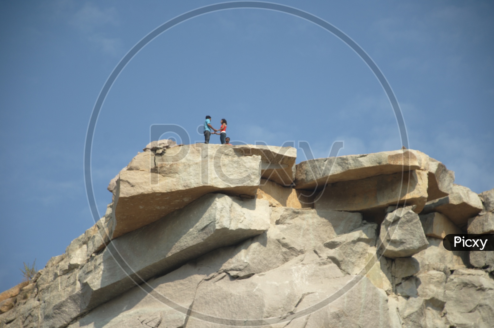 A couple holding hands on the top of a mountain