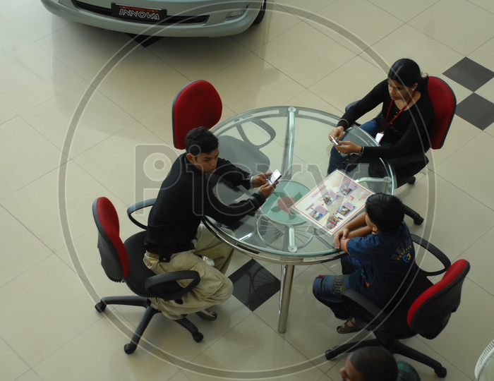 Kids sitting near a table in a car showroom