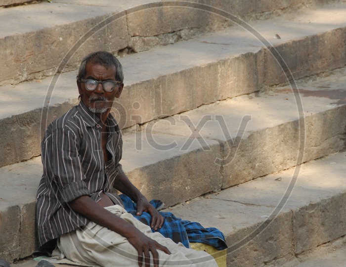 An old man sitting on the steps