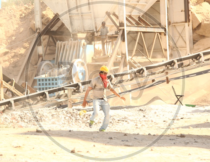 A Construction Man with Helmet Running  and Hydraulic Machines at a Construction Site
