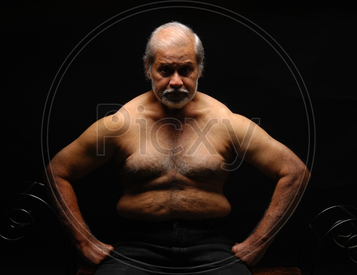 Photograph of a old man with studio lighting with black background / People Face
