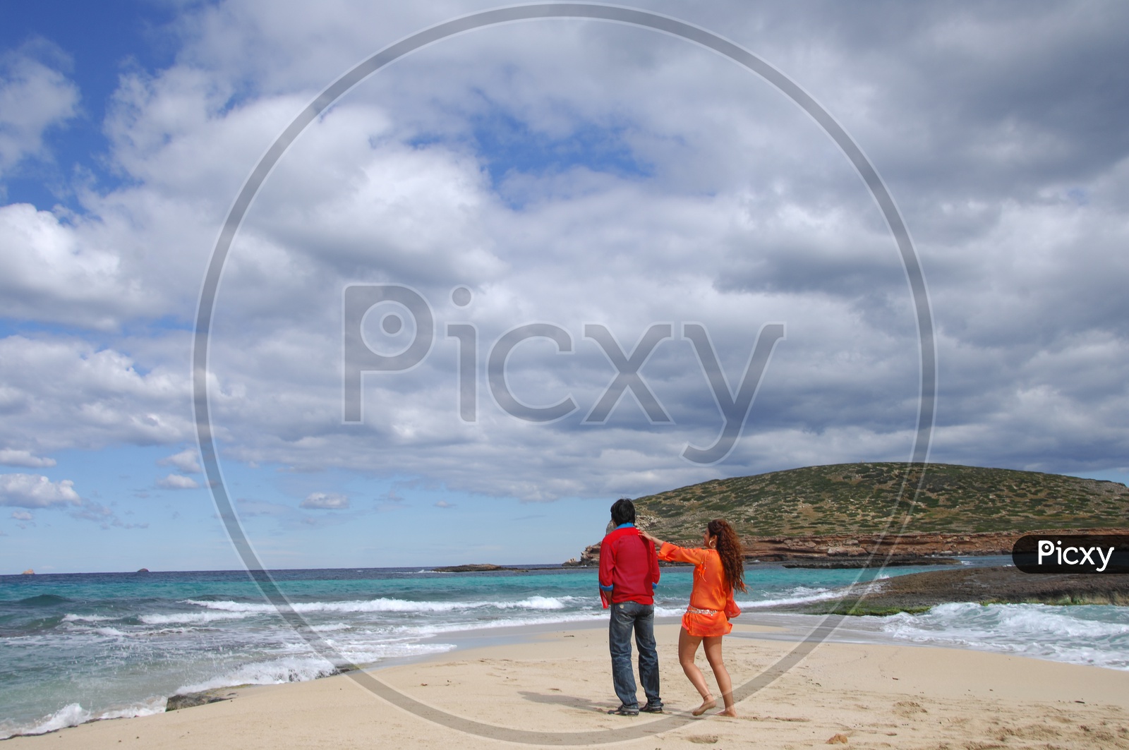 A Couple on a Rock Beach Watching the Sea
