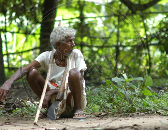 An Old Man Sitting On Ground in a Village