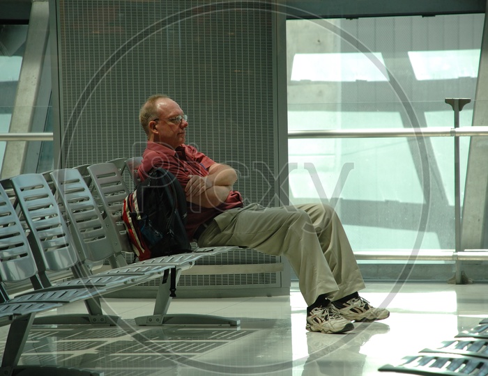 An old man waiting at the airport