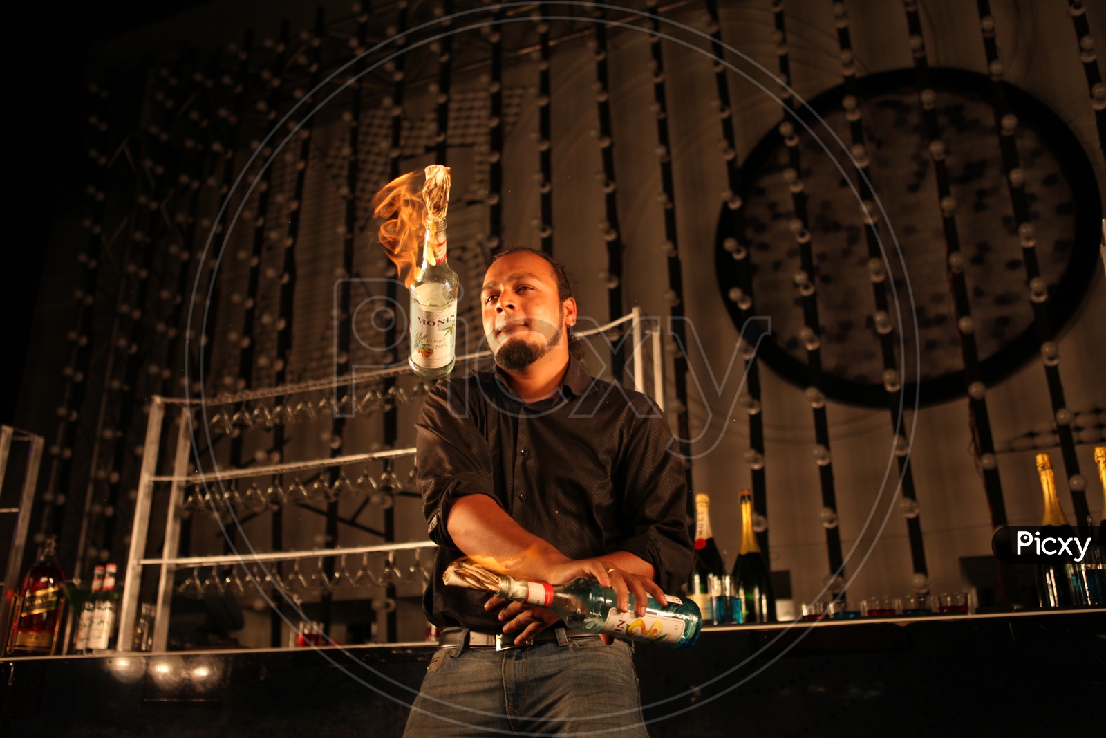 A Bartender Playing With Bottles in a bar