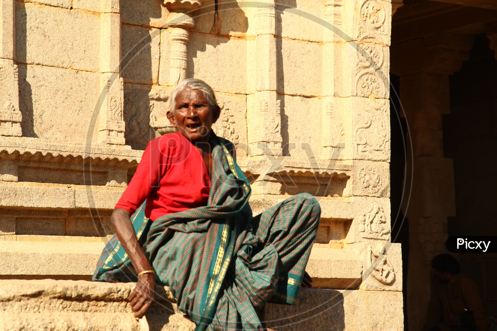 An old woman sitting at the temple
