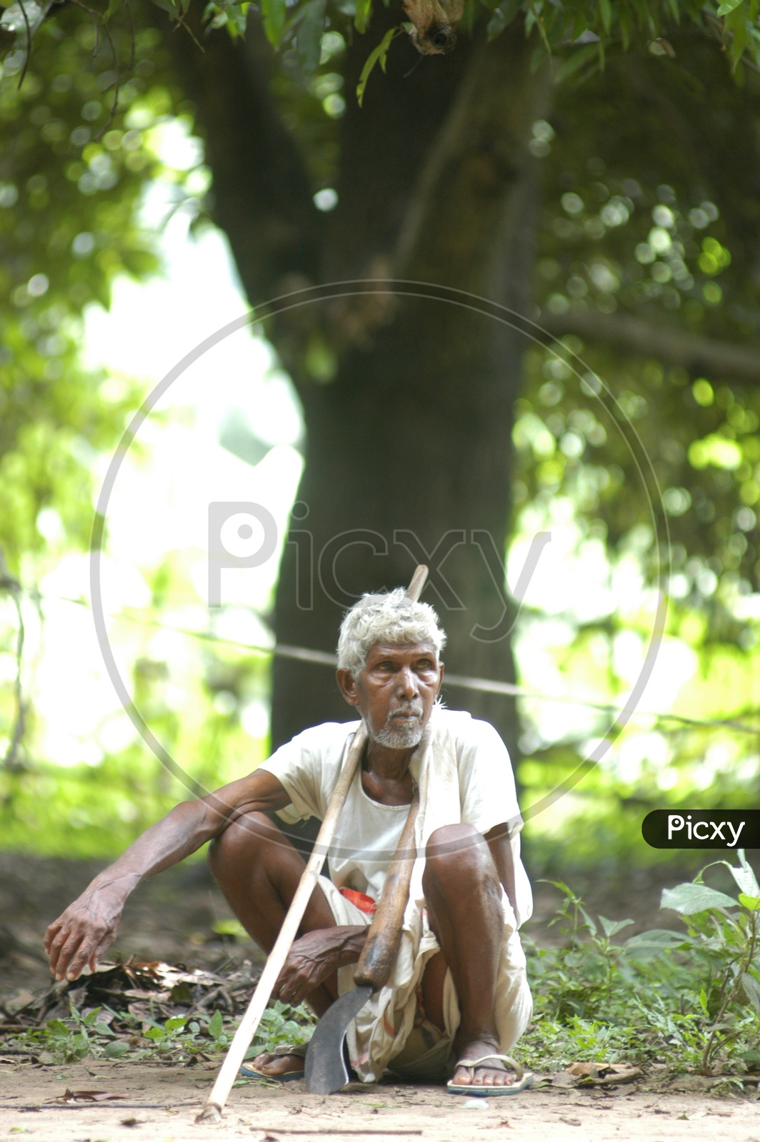 An Old Man Sitting On Ground in a Village