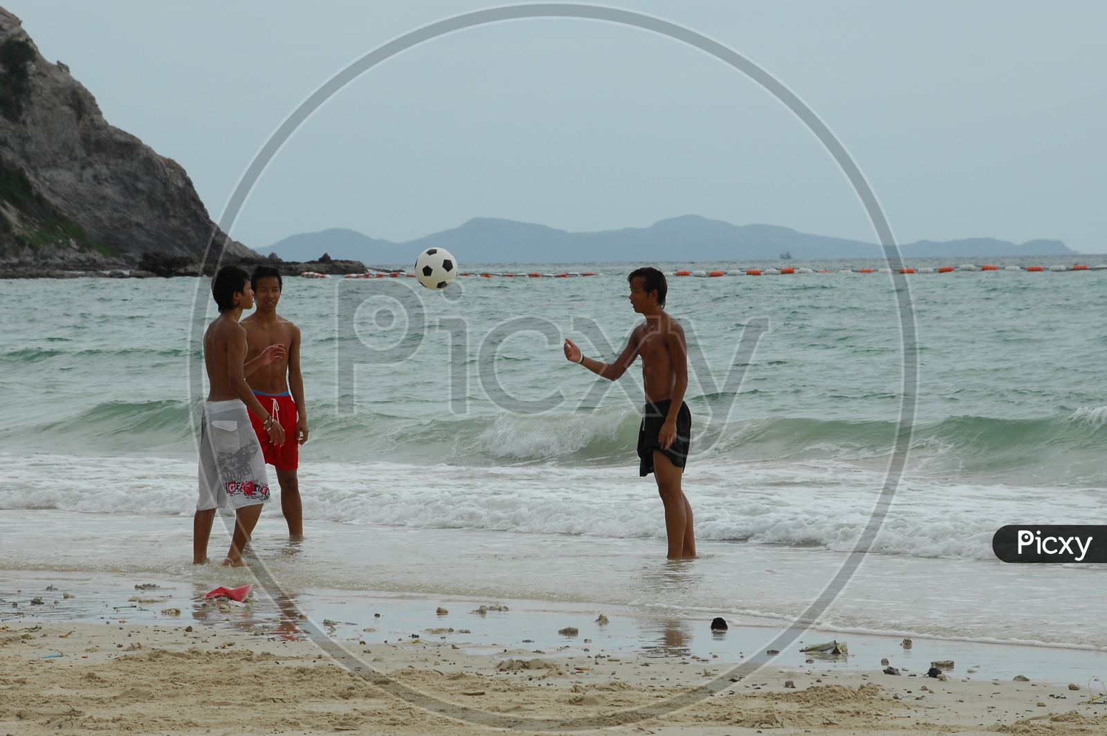 Boys playing football in the beach