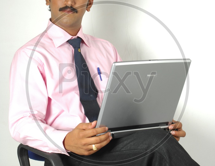 Indian man working infront of a laptop