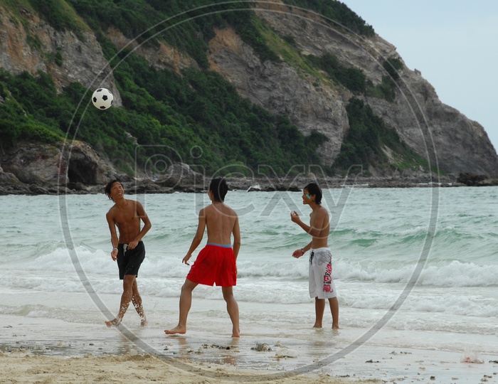Boys playing football in the beach