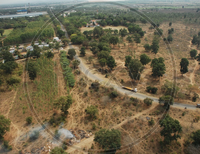 Photograph of Vehicles moving on a single road in Aerial View