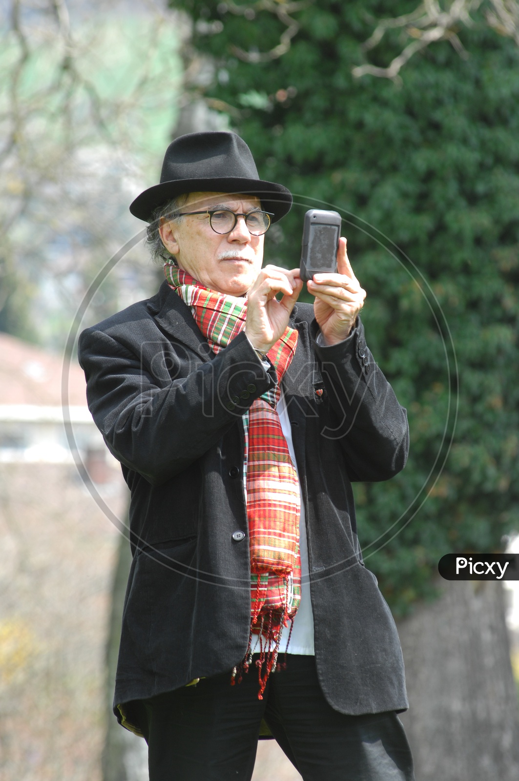 An old man clicking with a phone
