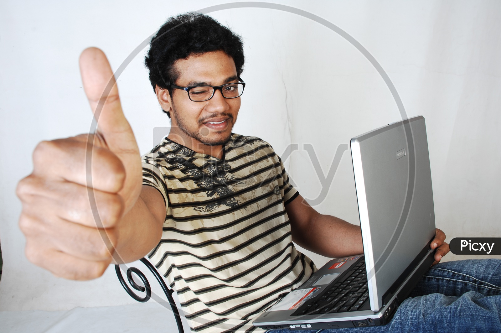 Young Indian Student With Laptop and Thumbsup Gesture