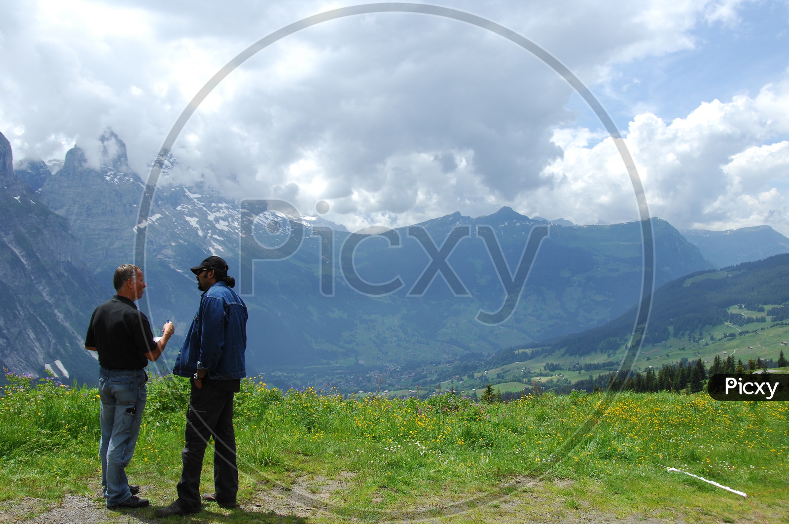 Image of Two men talking near a mountain area, clouds seen at a far ...