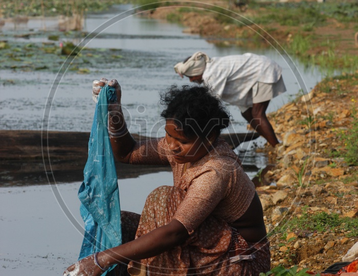 Women wash clothes in local lake