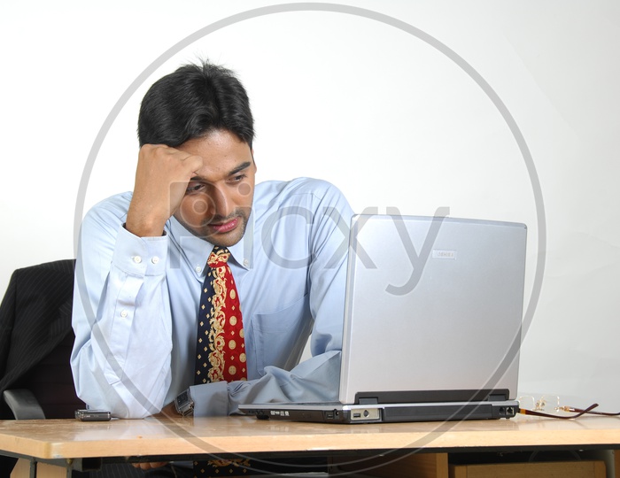 Indian man working  & frustrated with a laptop