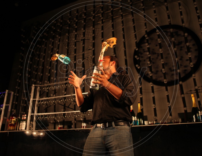 A Bartender Playing With Bottles in a bar