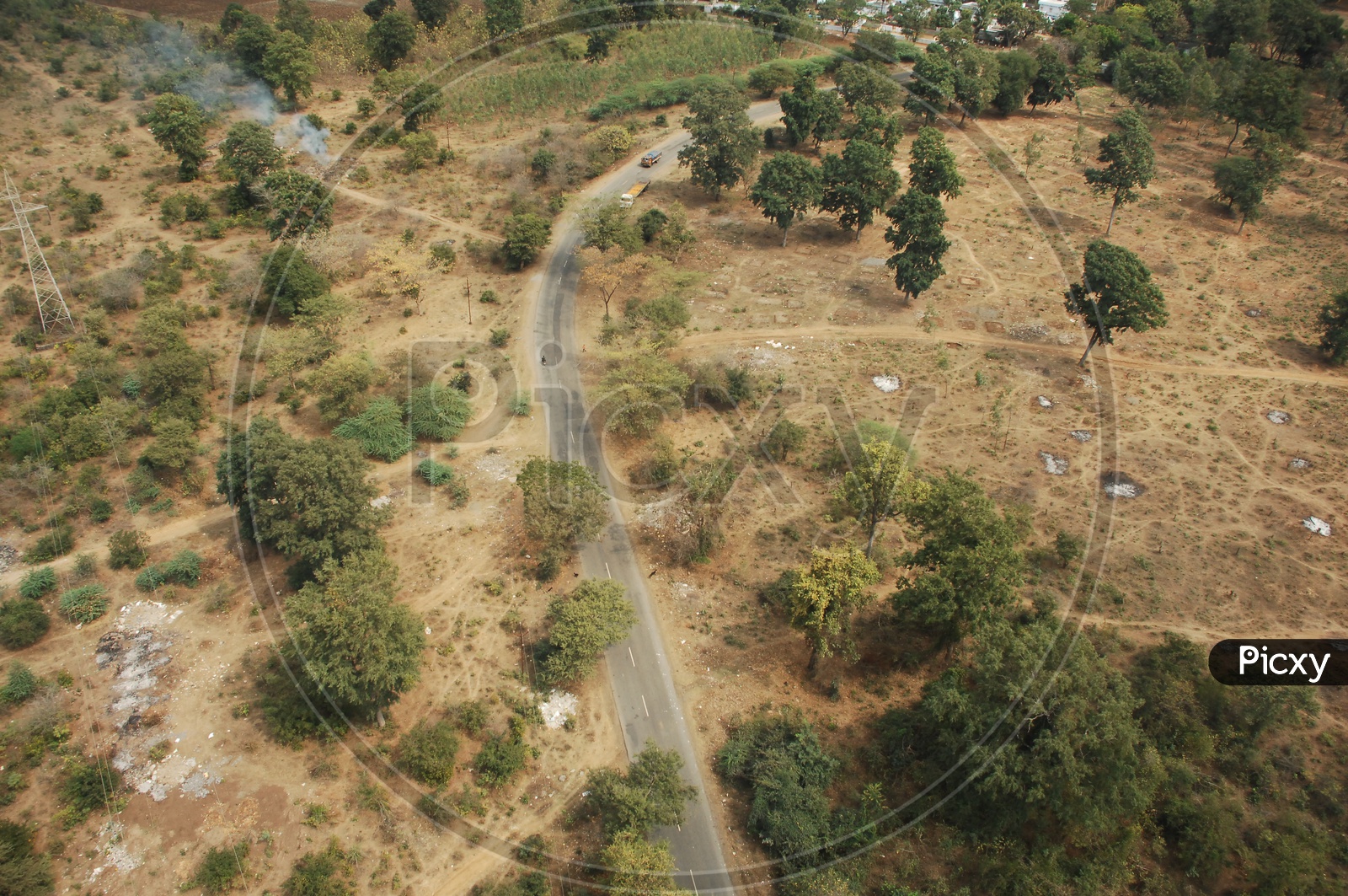 Photograph of Vehicles moving on a single road in Aerial View