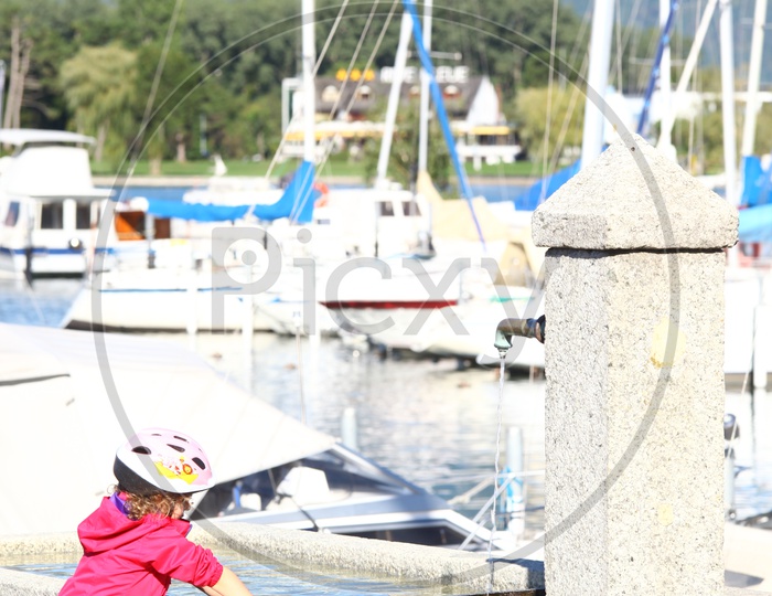 A girl in pink hoodie at the harbor