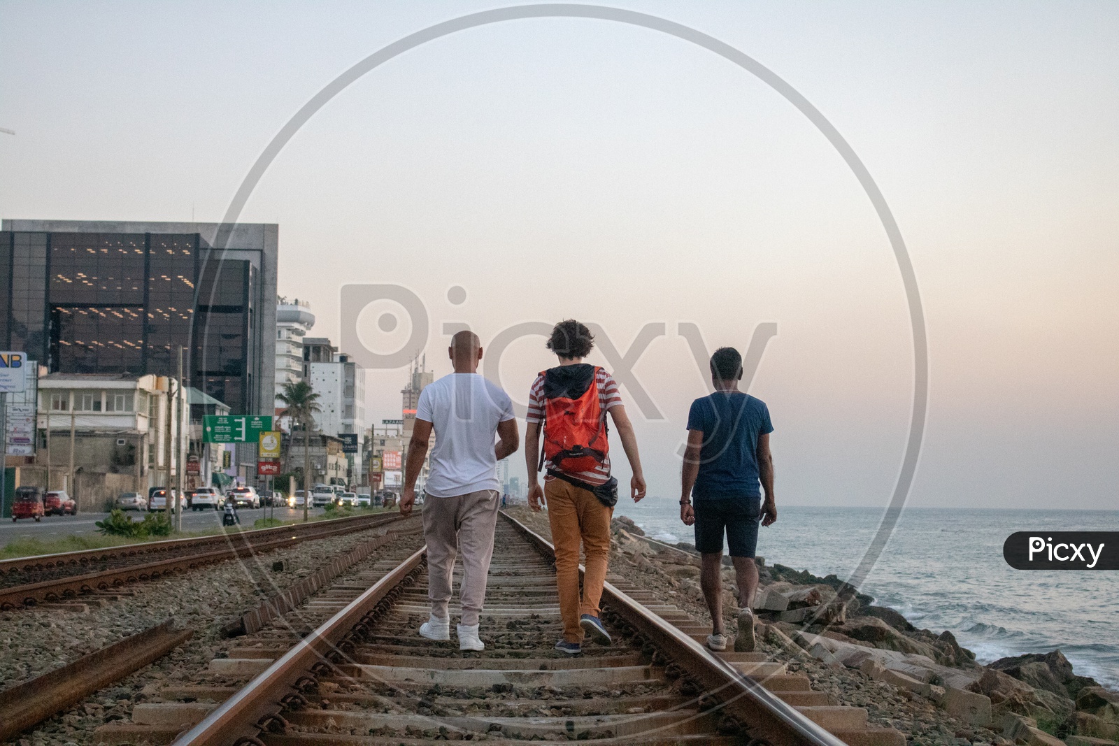 Tourist Friends walking on railway track by the beach in Colombo