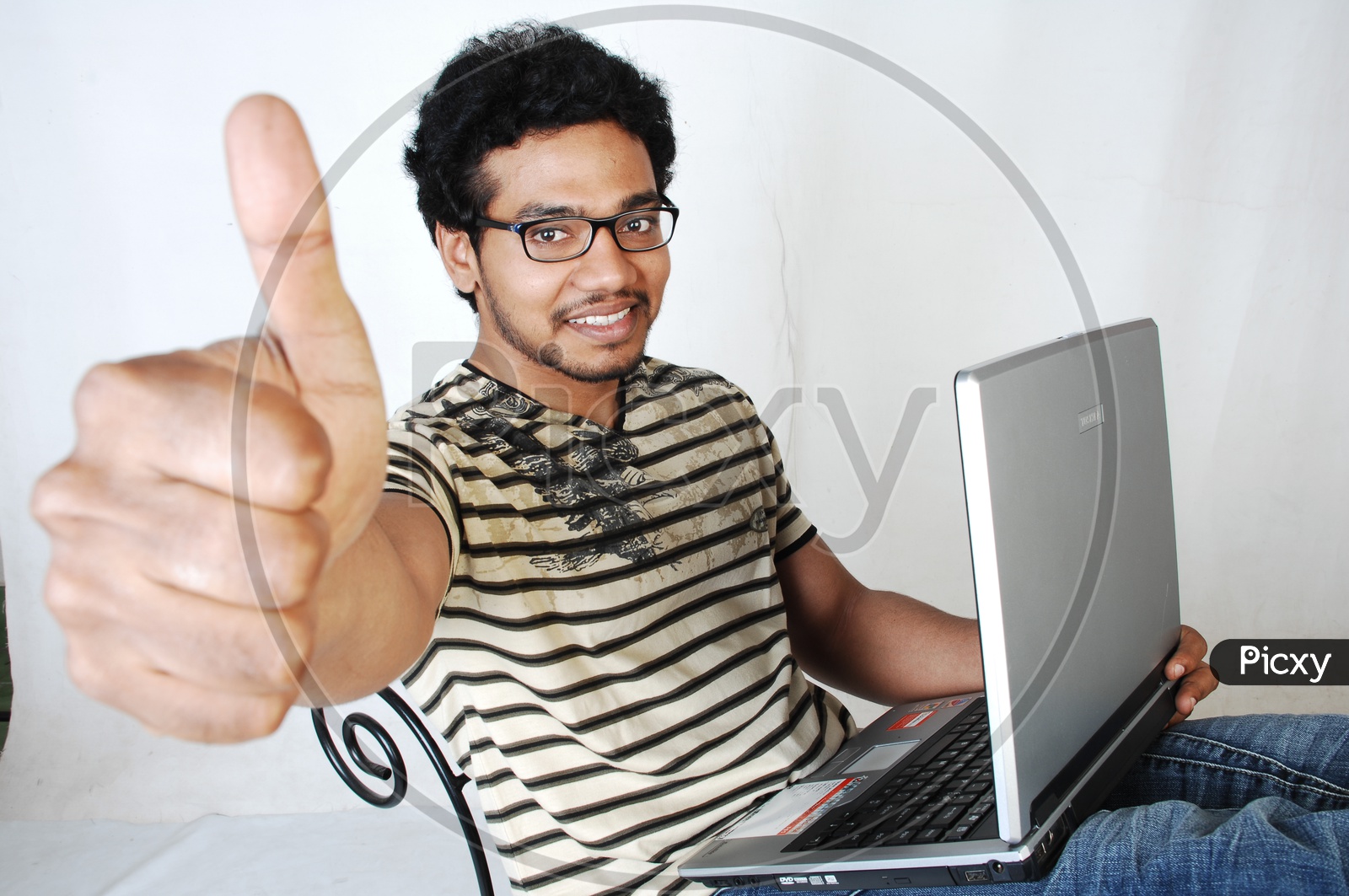 Young indian Student with a laptop Thumpsup gesture