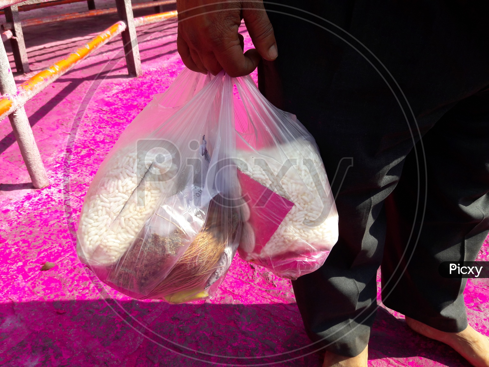Indian Hindu Devotee Carrying Puffed Rice and Coconut In a Plastic Cover at Hindu Temple