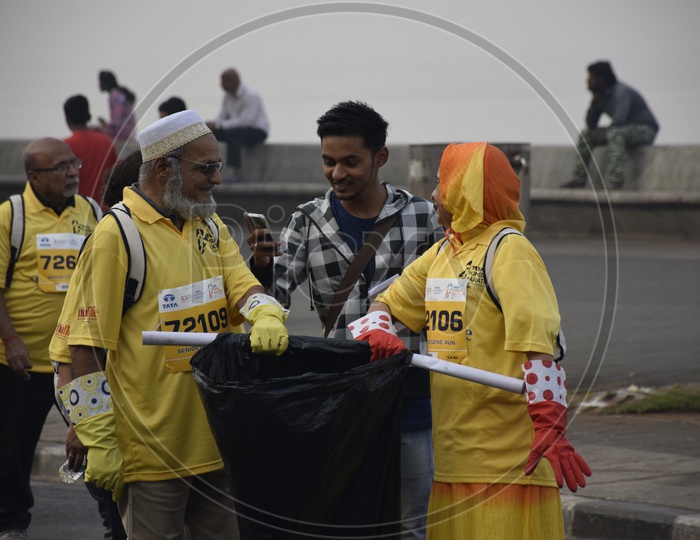 Old couple cleaning trash at a marathon