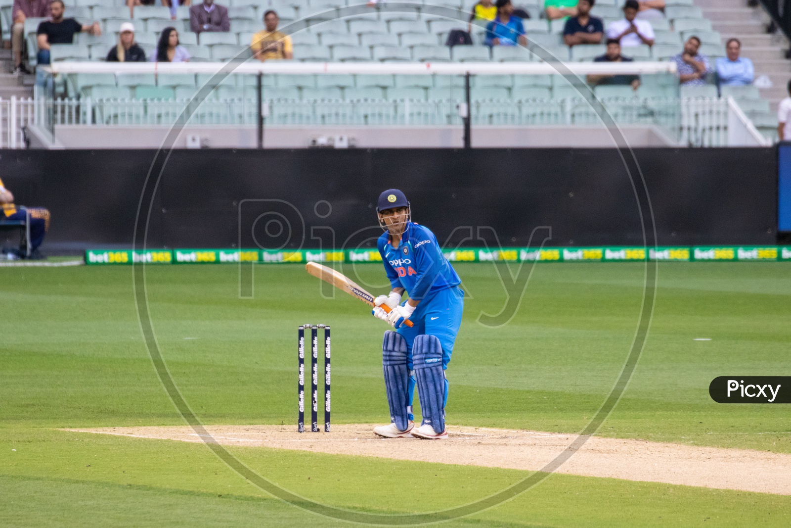 MS Dhoni on a Cricket Stadium  in Batting Position