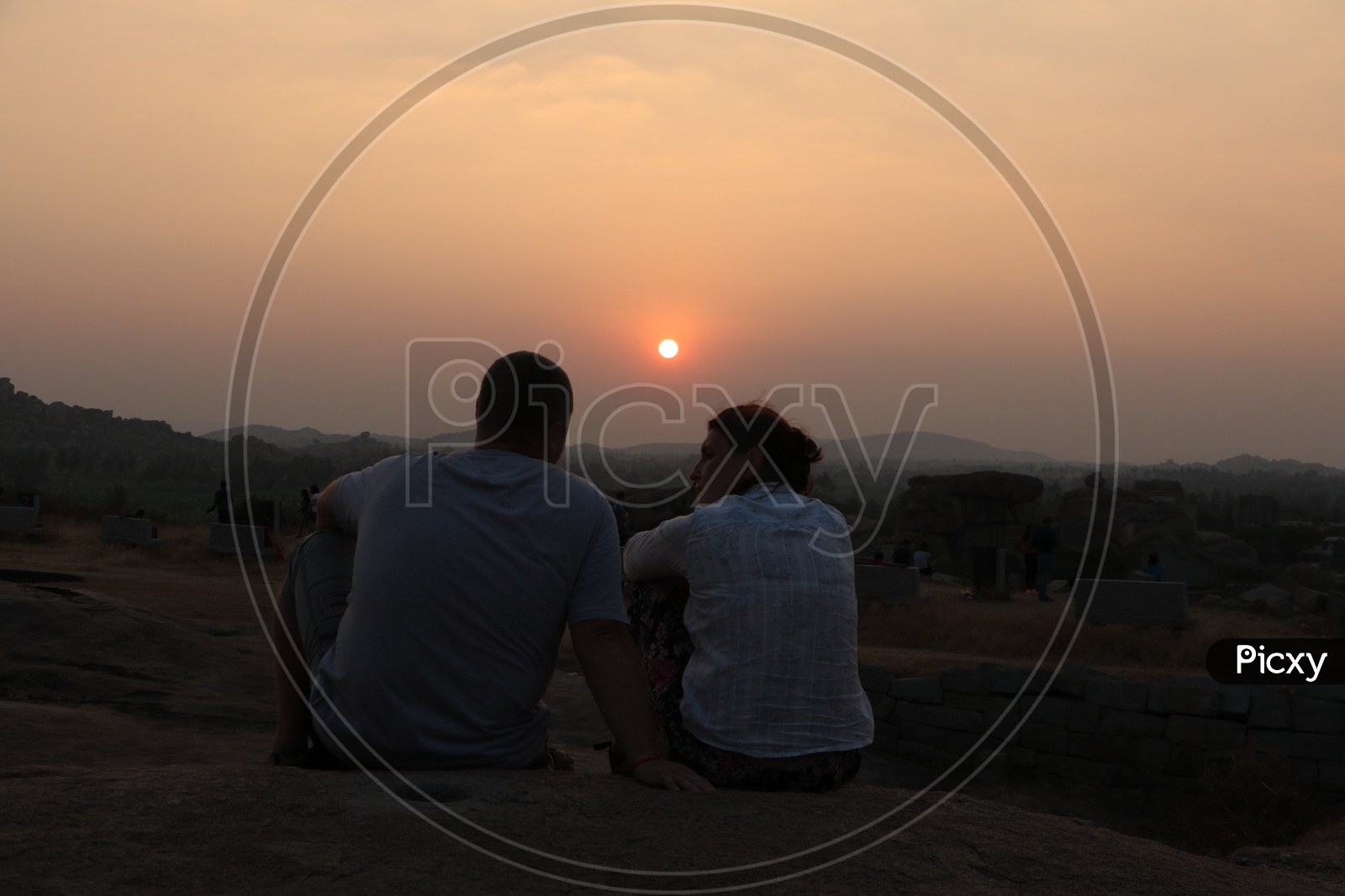 A Couple Enjoying the Sunset Over the Rock Hill Chain From a Hill Top in Hampi , Karnataka